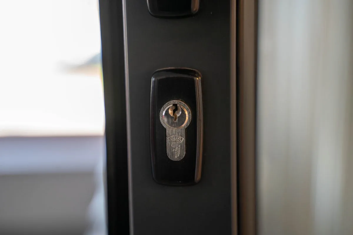 Close-up of a steel lock cylinder and keyhole on a door