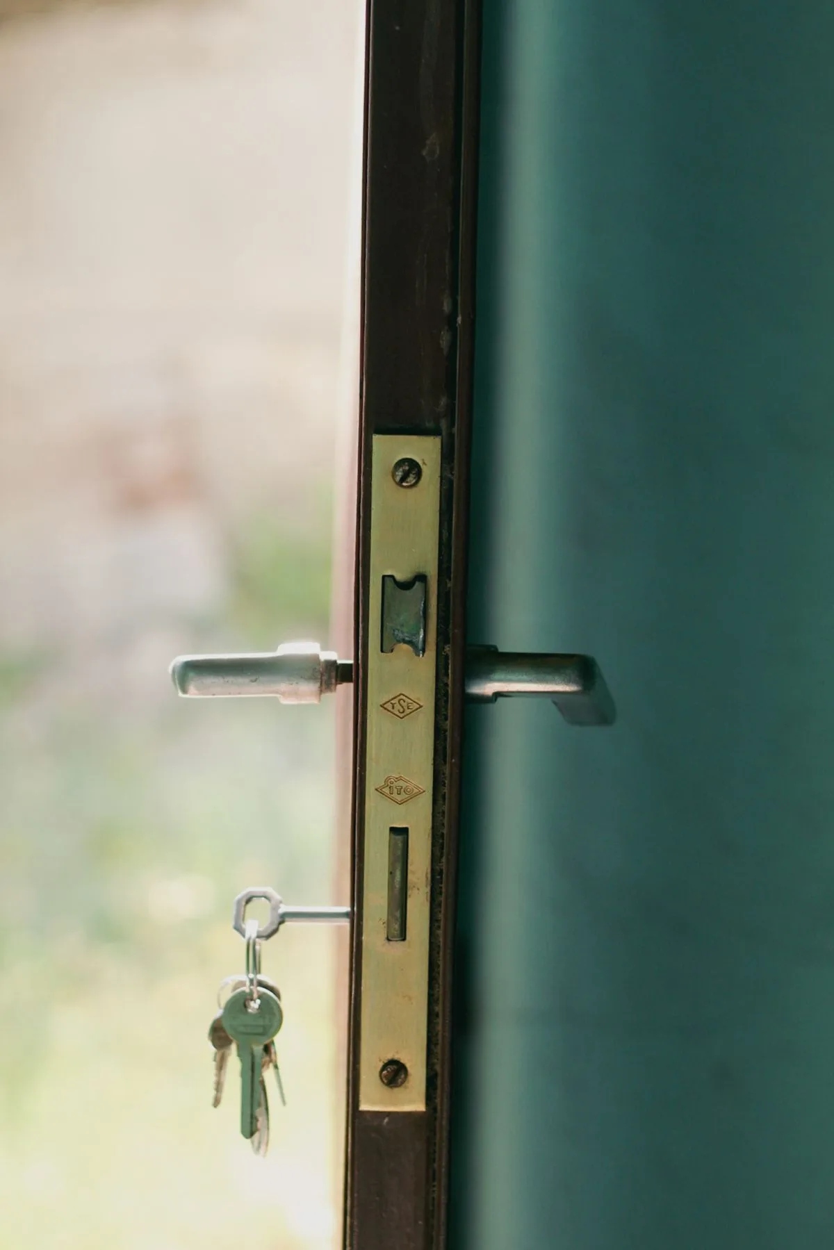 Close-up of a door lock with keys inserted, lit by natural sunlight
