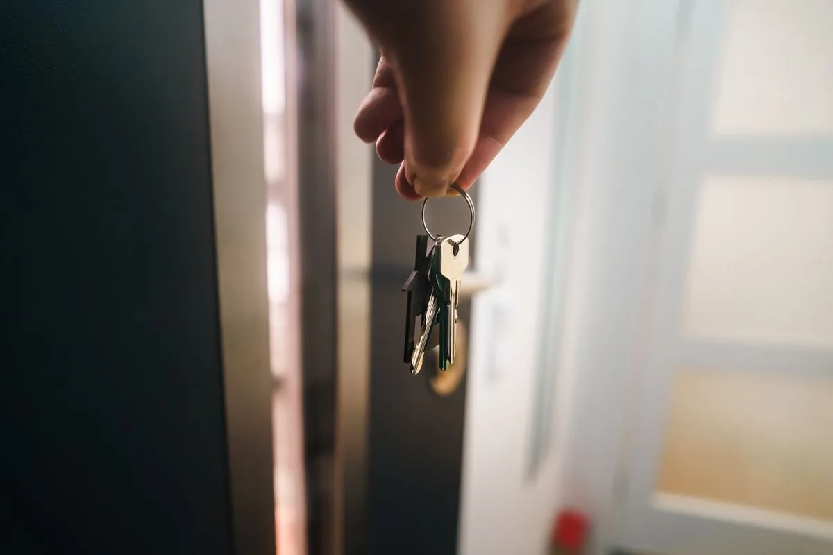 Close-up of a hand holding a set of keys at a doorway