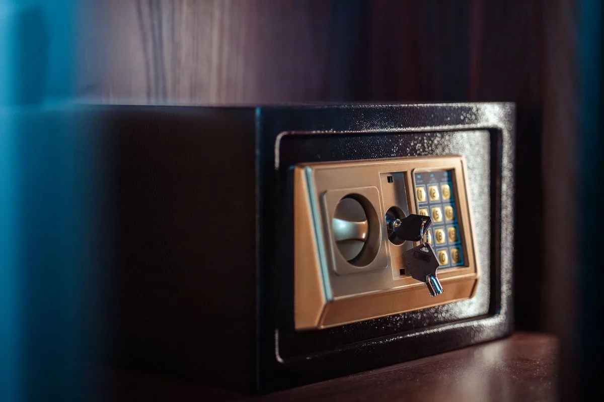 Close-up of an electronic safe with a keypad and a key