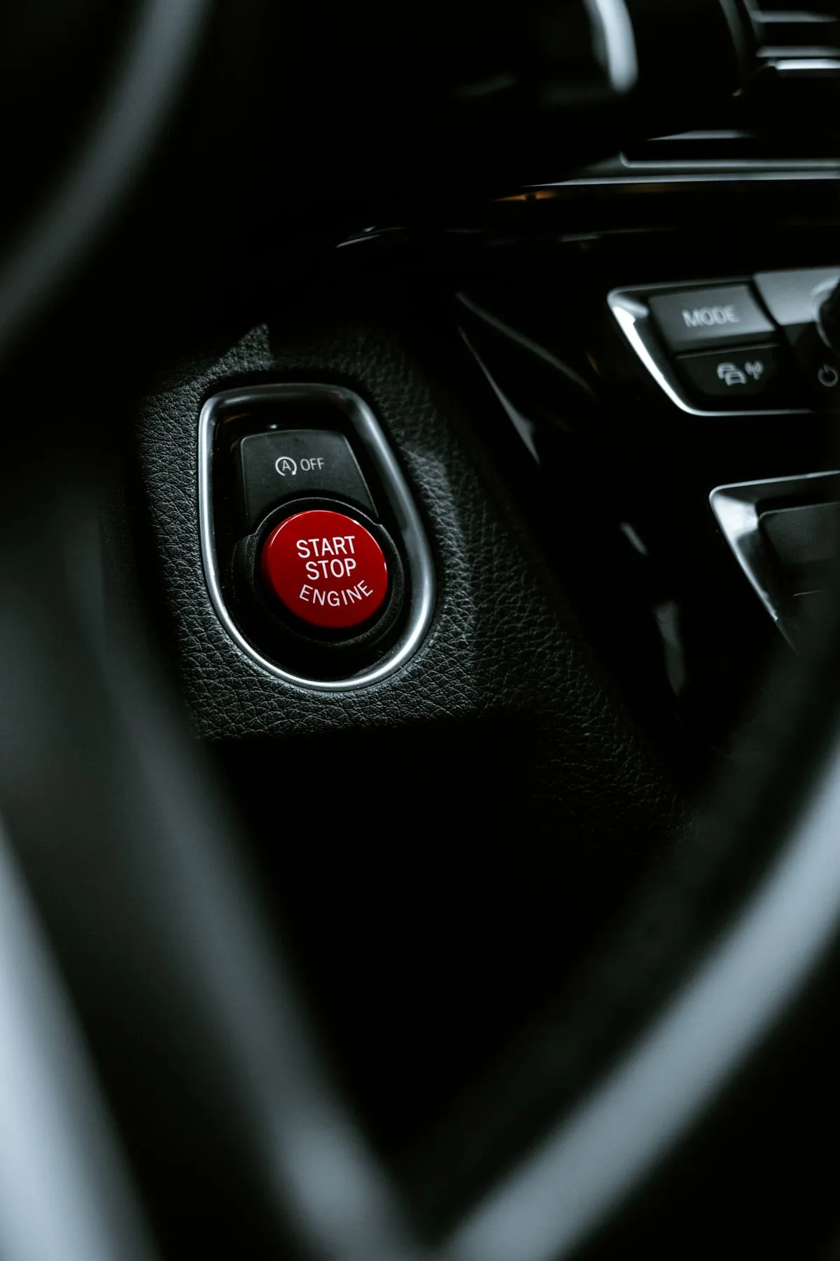 Close-up of a push-to-start engine start stop button on a car dashboard
