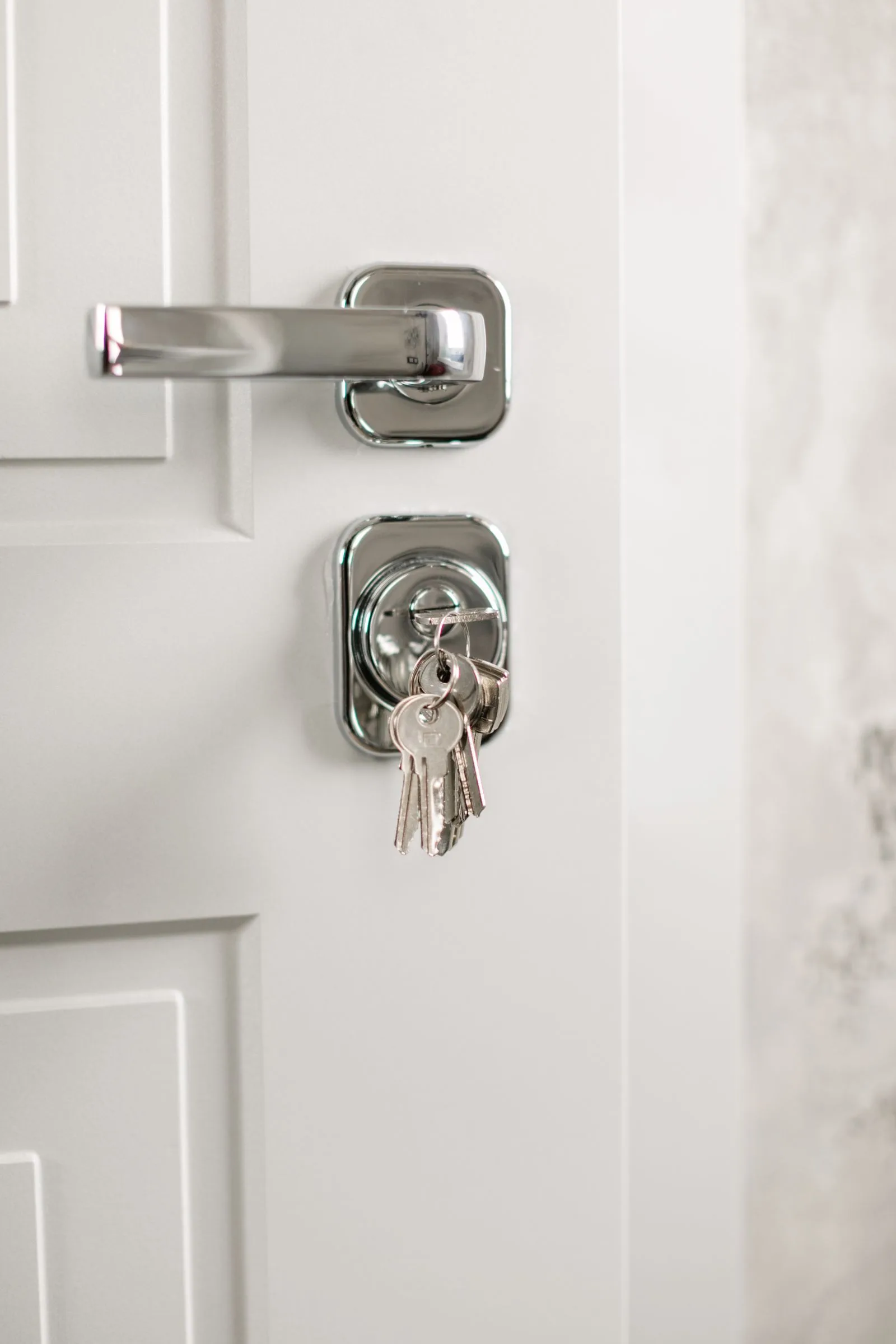 Modern silver door handle with keys hanging in the lock