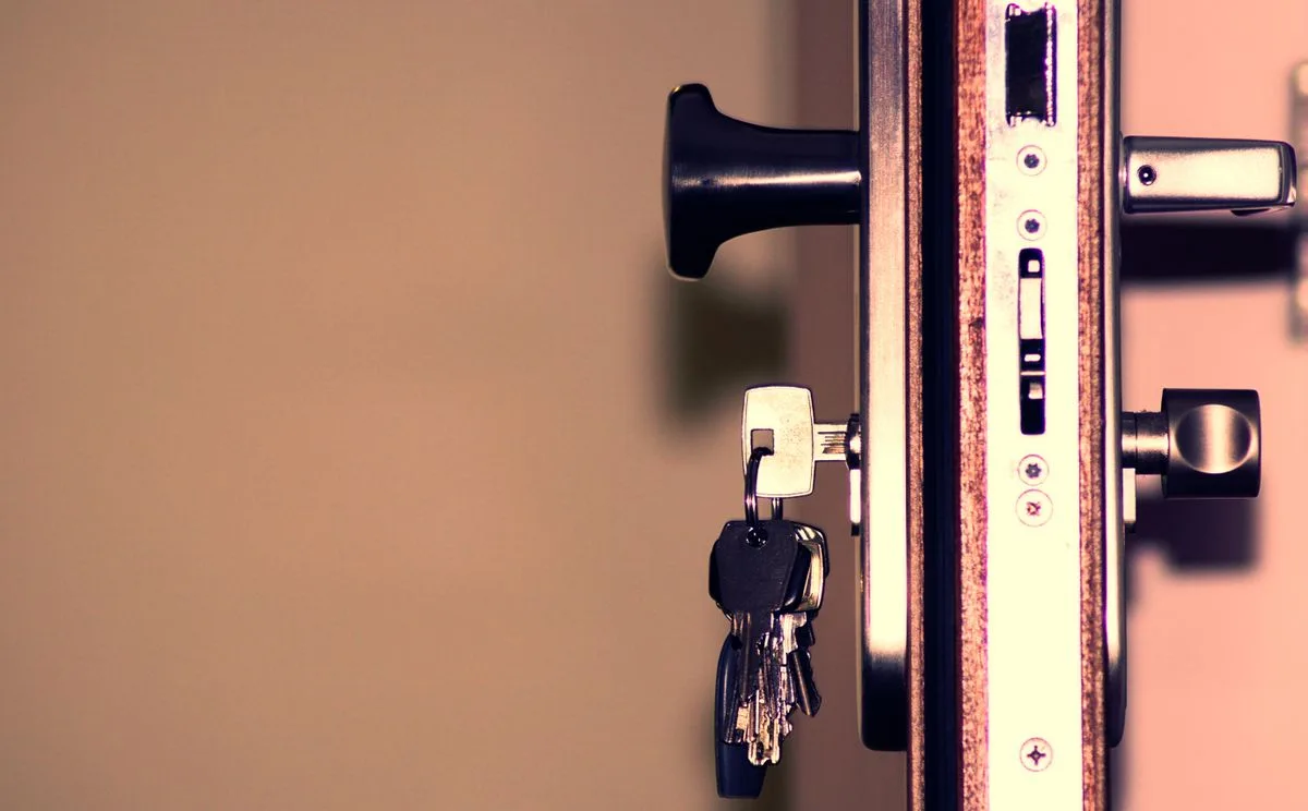 Close-up of a door lock with keys in the cylinder